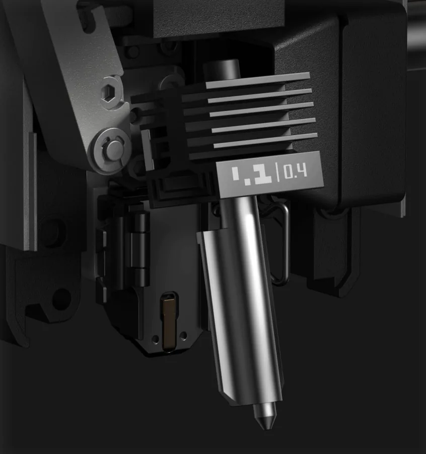 Bambu Lab P2S quick-swap hotend in the toolhead: finned heatsink, steel nozzle and the wire latch that holds it