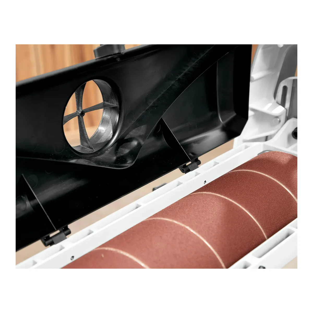 JET JWDS-2550 with the black dust hood raised over the sanding drum, showing the round dust port molded into the hood and the spiral wrap of abrasive on the drum