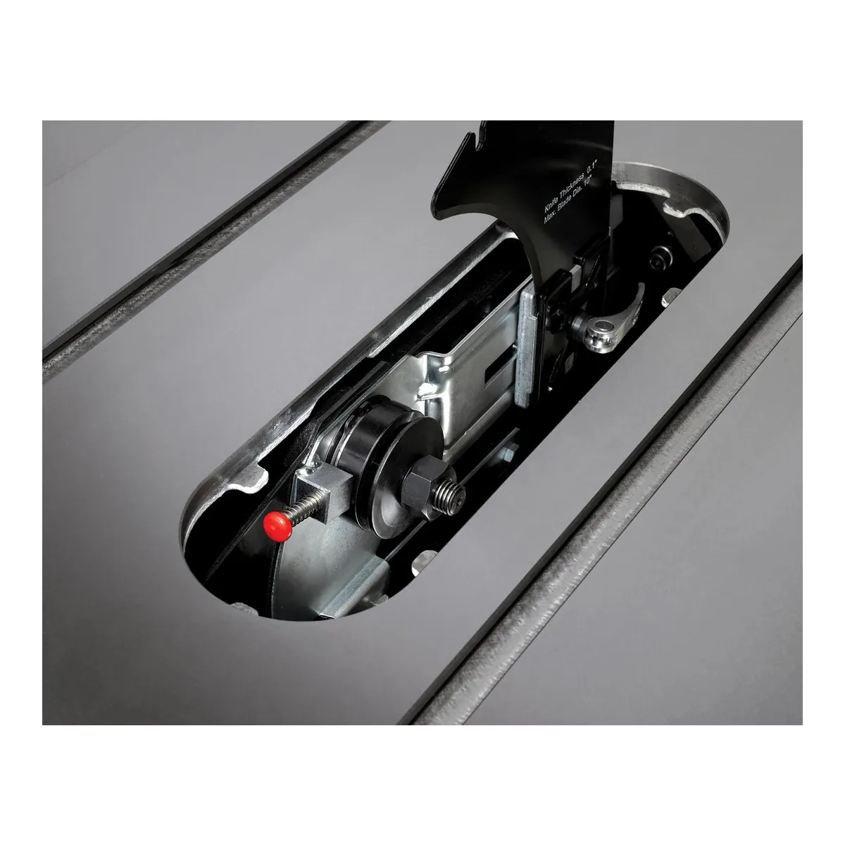Throat plate removed on the JET Deluxe XACTA showing the arbor, the arbor nut and the red push button arbor lock beside it