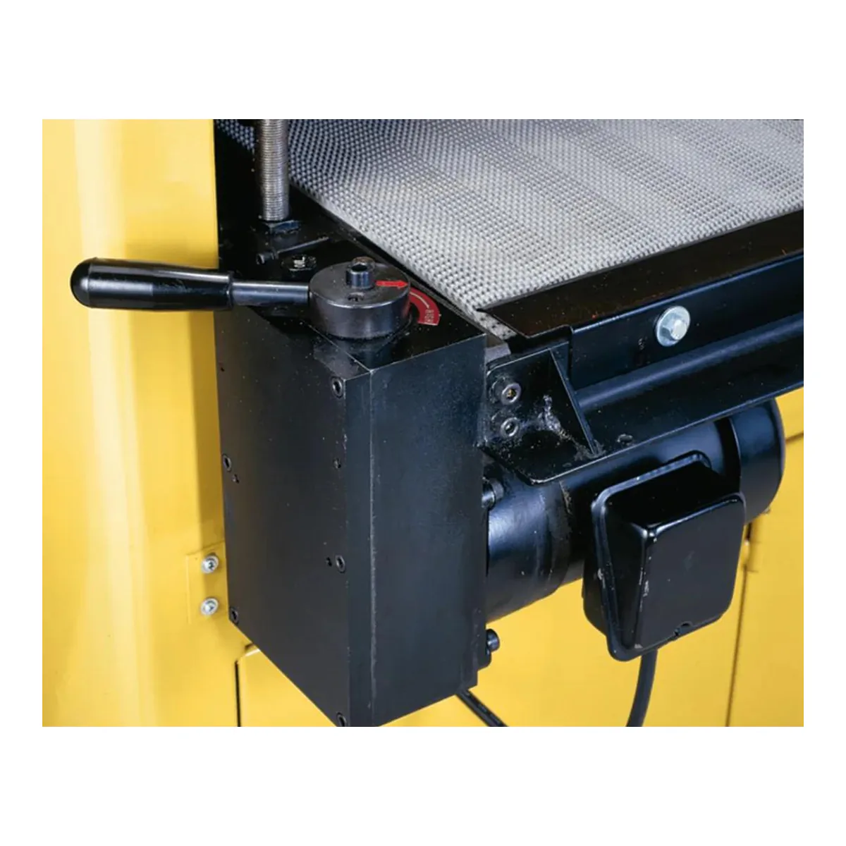 Powermatic DDS-225 conveyor gearbox with its lever handle and red direction arrow, beside the feed motor
